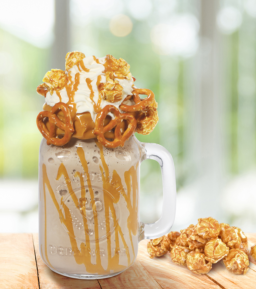 Milkshake covered with whipped cream, pretzels, and caramel popcorn.